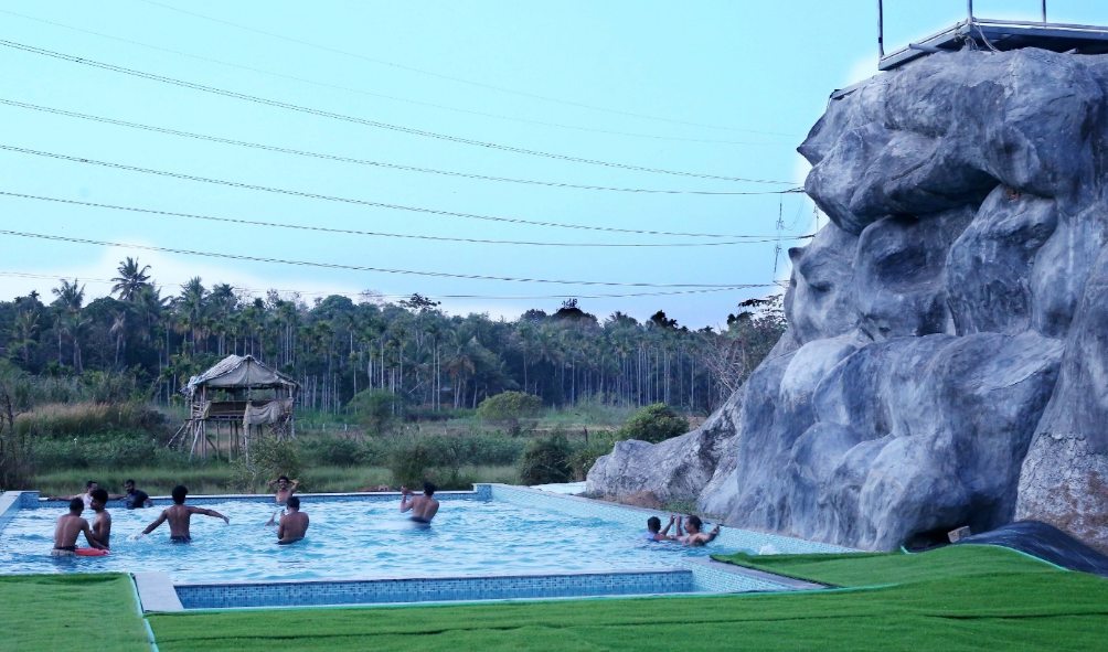 Pool with rock waterfall feature at Clay Club Farm Stay